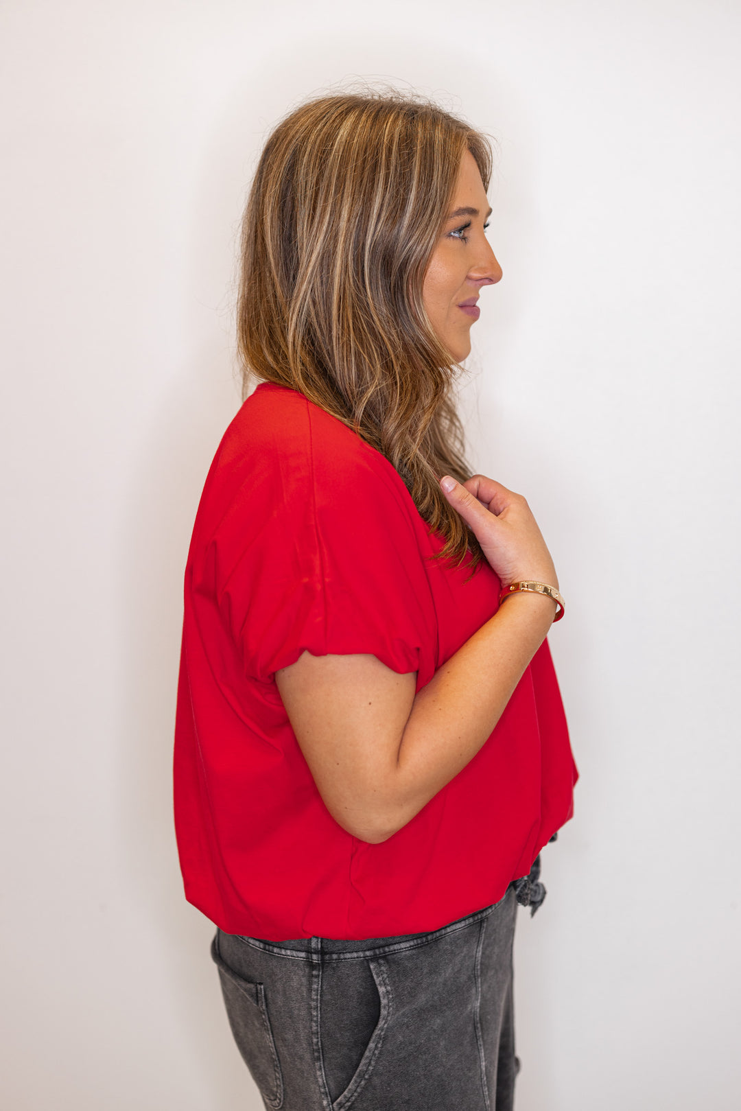 Side view of Women's red Bubble hem top.