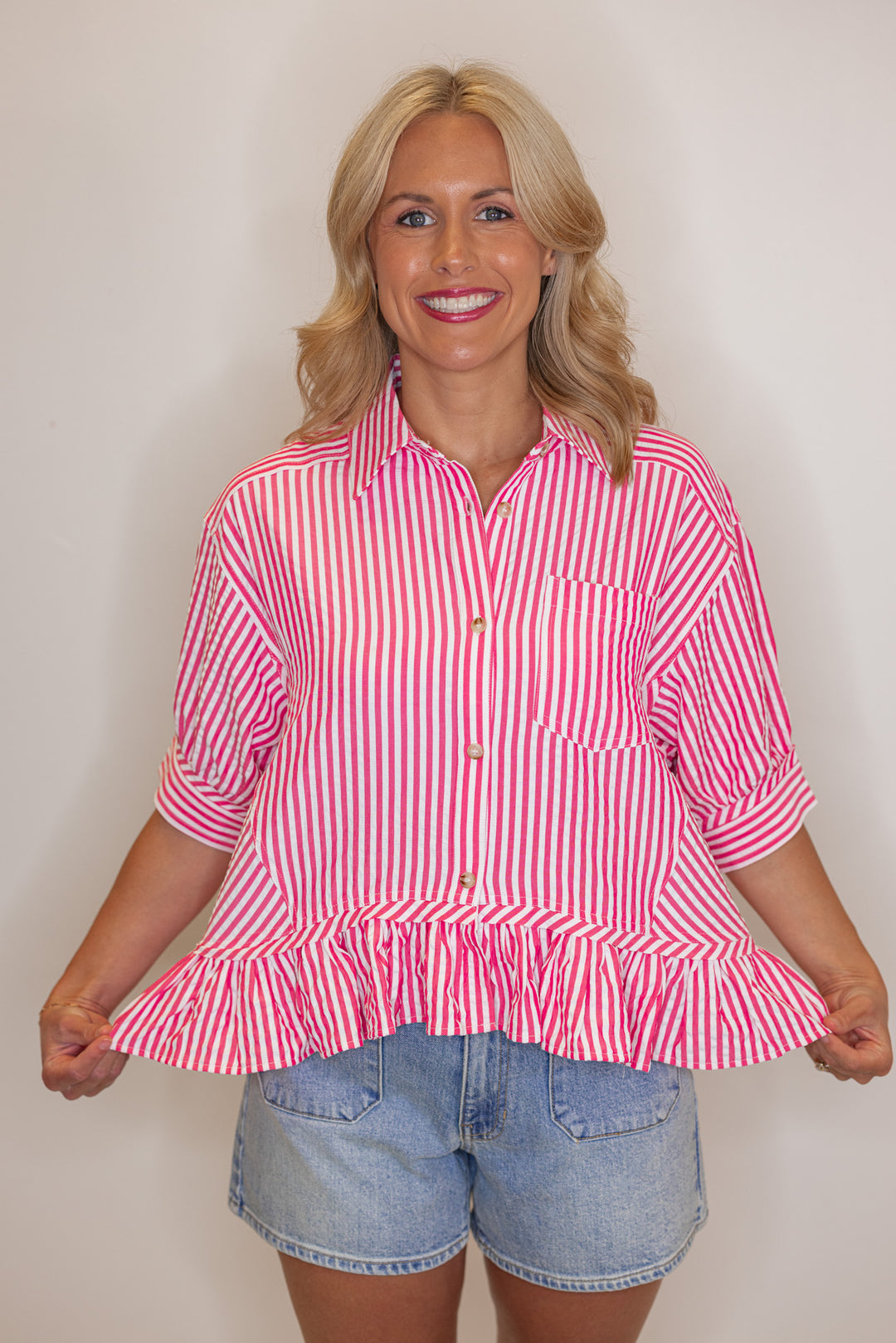 Women's pink summer striped button down top with ruffled bottom hem by Entro showing ruffle width