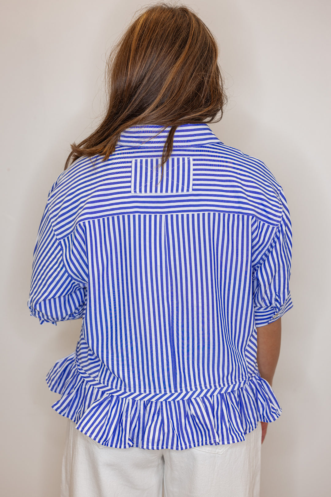 Women's blue summer striped button down top with ruffled bottom hem by Entro showing back view