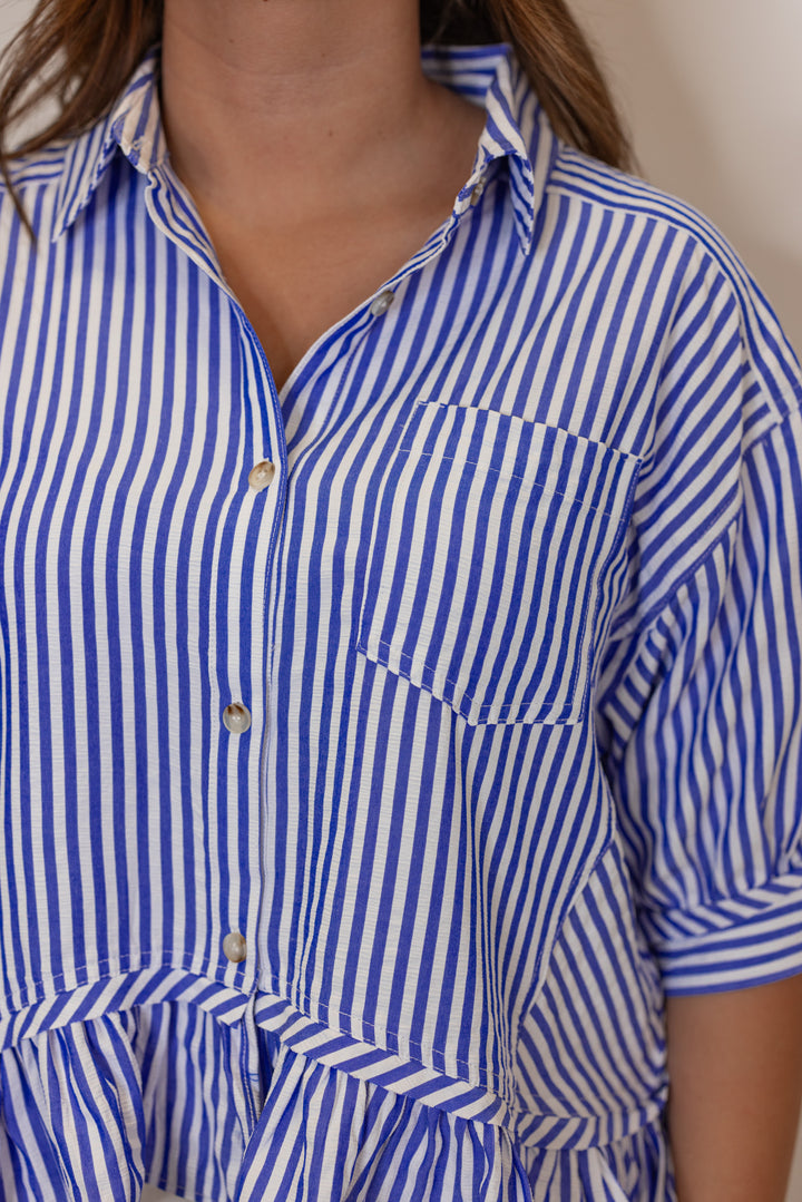 Women's blue summer striped button down top with ruffled bottom hem by Entro showing up close front view