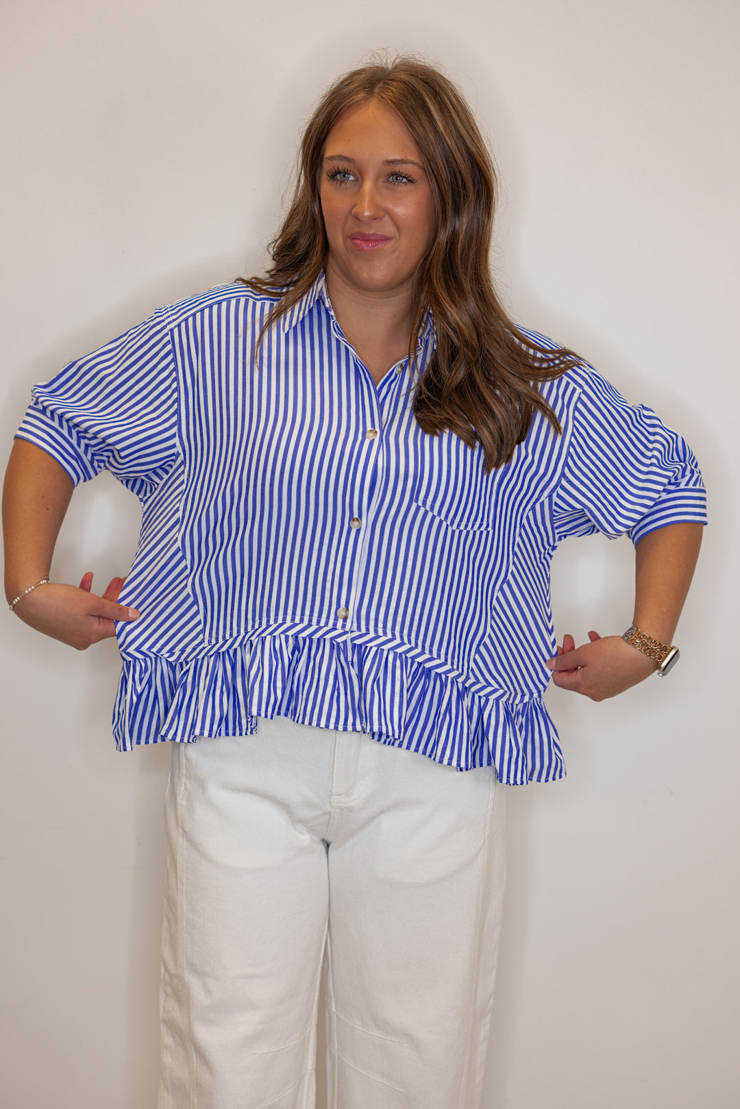 Women's blue summer striped button down top with ruffled bottom hem by Entro showing shirt's width