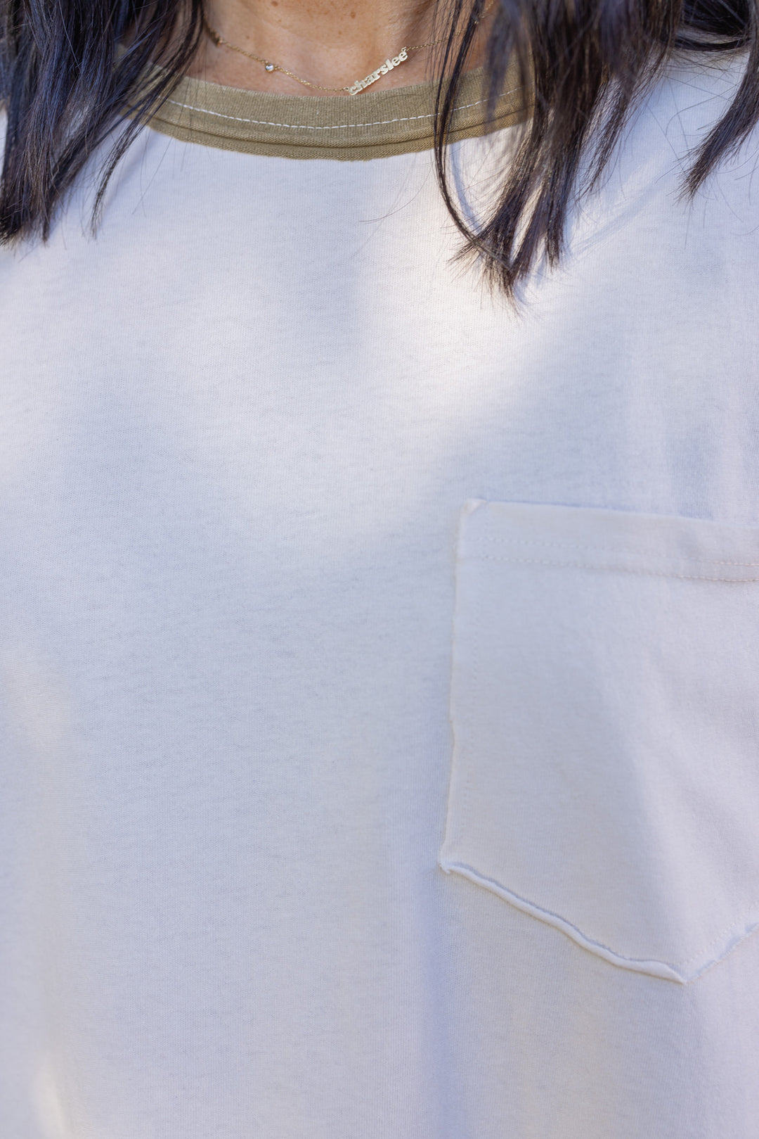 Women's washed ecru knit top with striped trim and floral details at the sleeves by Easel showing front chest pocket