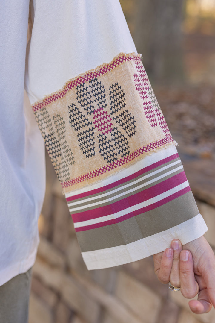Women's washed ecru knit top by Easel showing striped trim and floral details at the sleeves