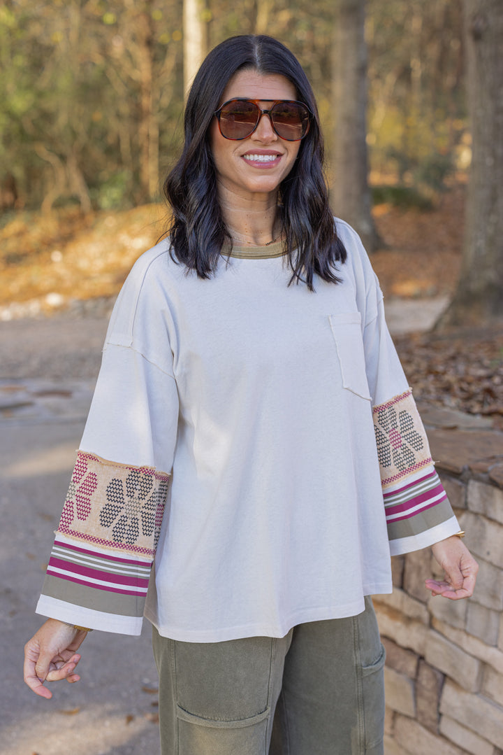 Women's washed ecru knit top with striped trim and floral details at the sleeves by Easel showing slight angled front view