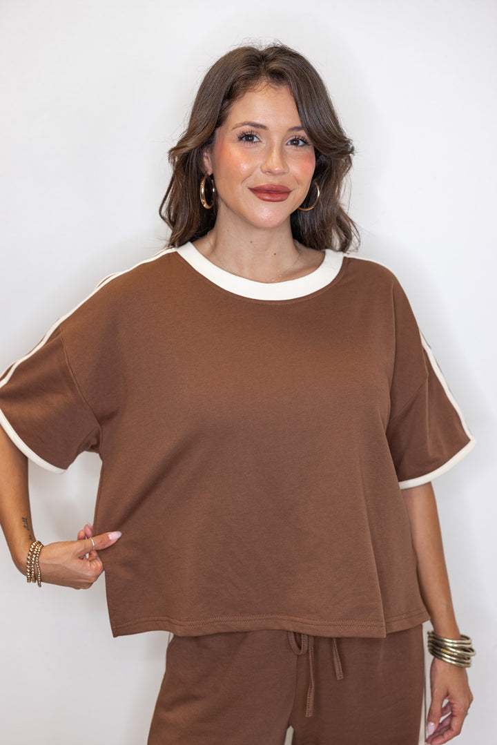 Women's brown french terry knit top with cream stripes on the sleeve by Entro showing relaxed, boxy fit