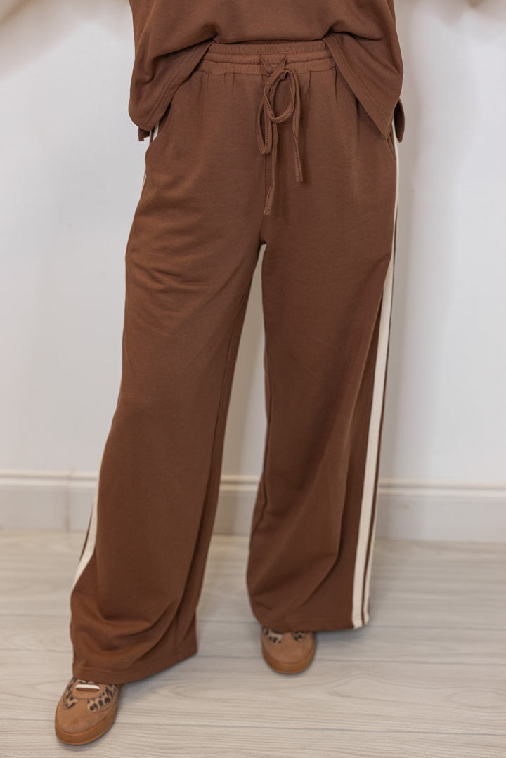 Women's brown french terry knit wide leg pants with cream stripes on the side by Entro showing up close front view