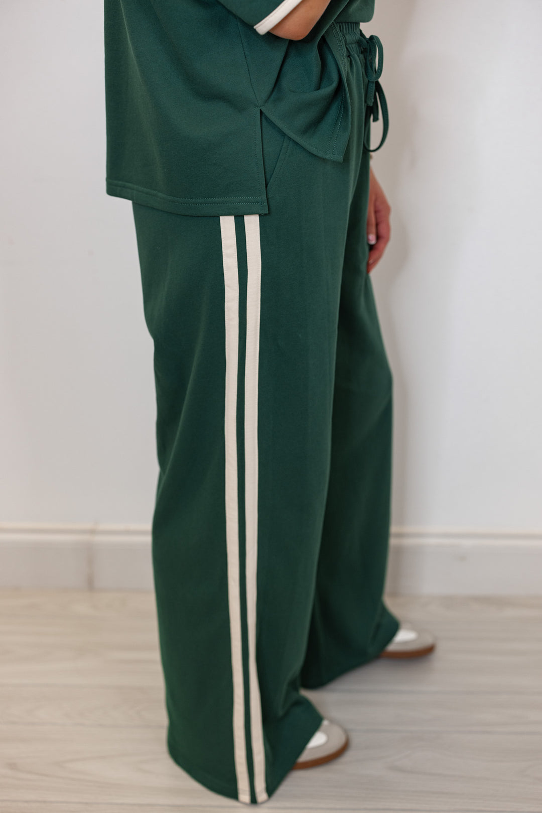 Women's hunter green terry knit wide leg pants with cream stripes on the side by Entro showing up close side view