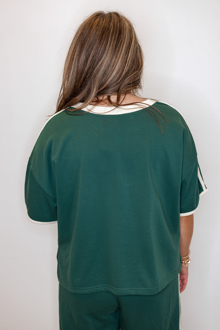 Women's hunter green french terry knit top with cream stripes on the sleeve by Entro showing up close, back view