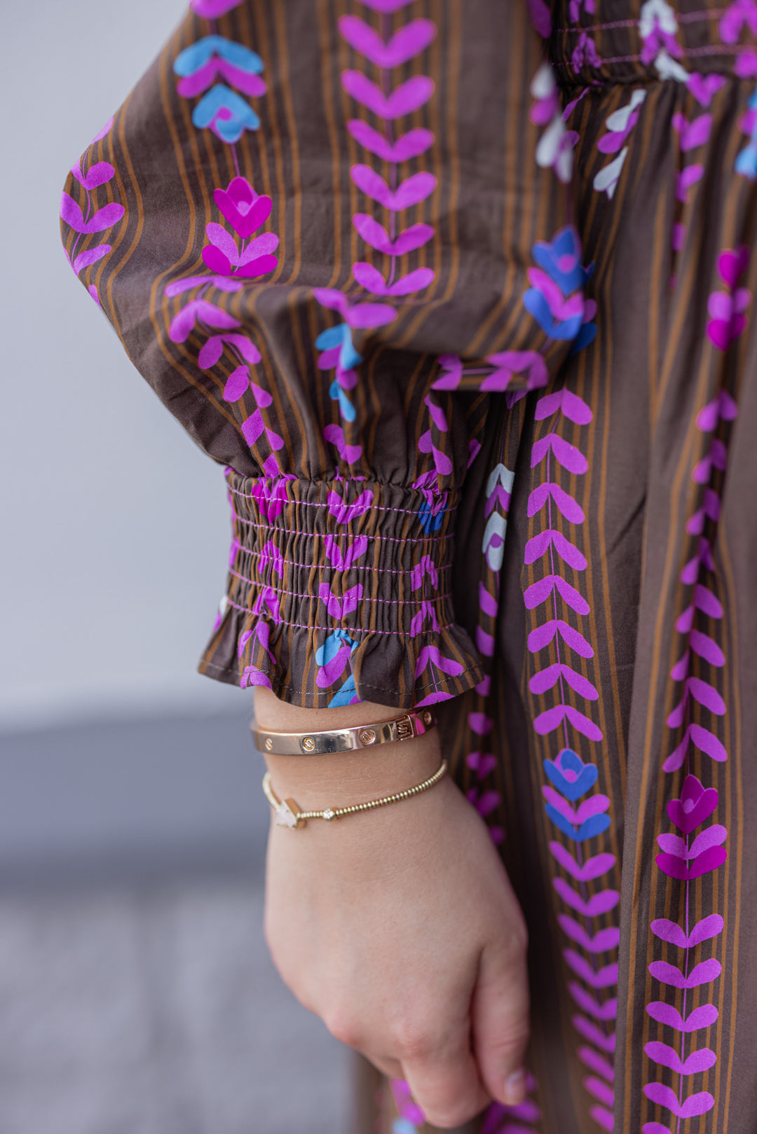 Women's brown ruffle trimmed midi dress with pink multicolor petal print by Umgee showing smocked detail on cuff sleeves