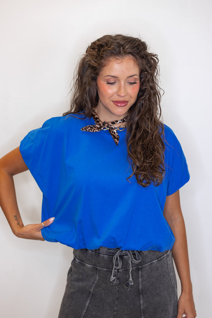 Women's royal Bubble hem blue top with a leopard print scarf necklace.