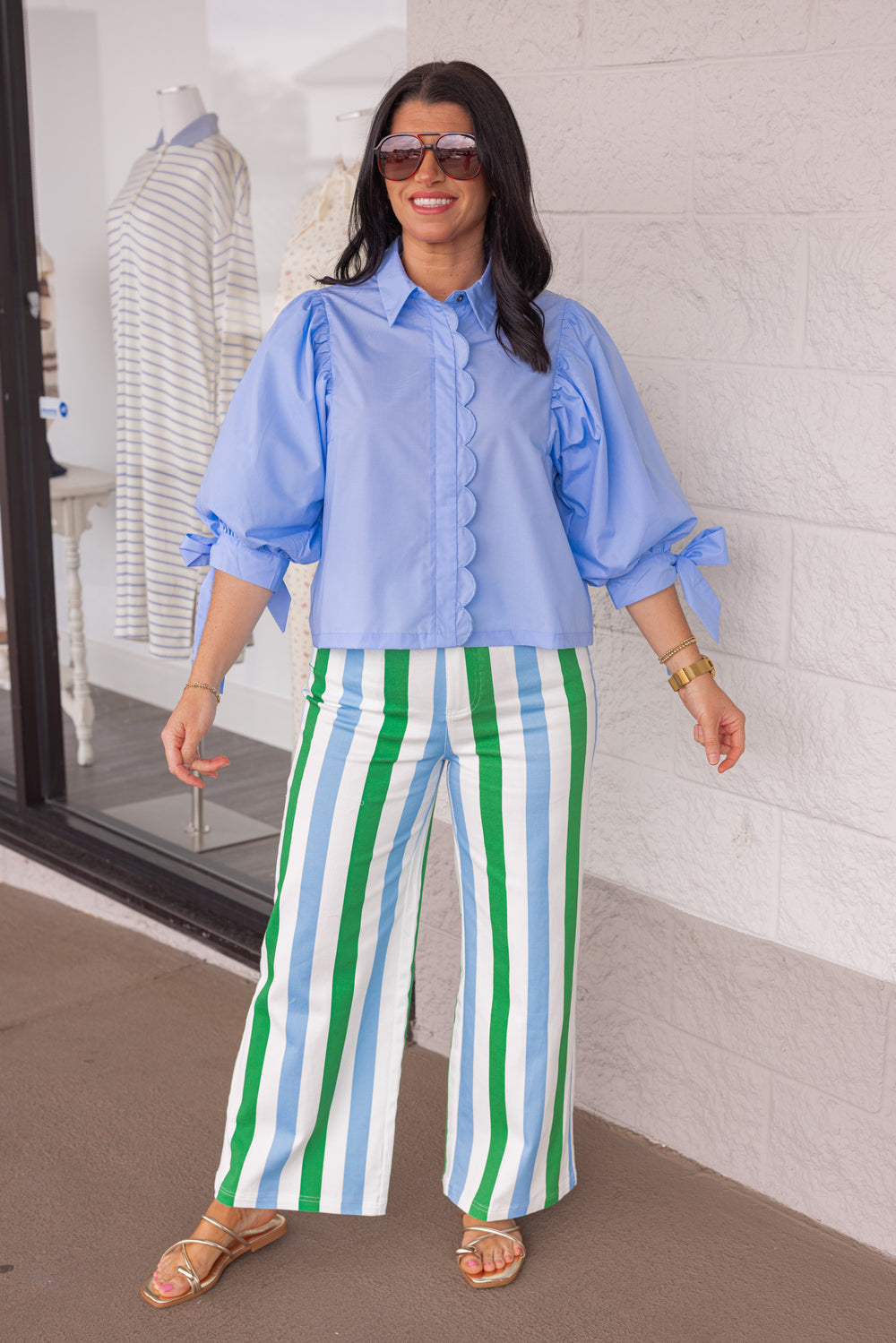 Light blue blouse paired with a pair of  green, blue and white striped pants