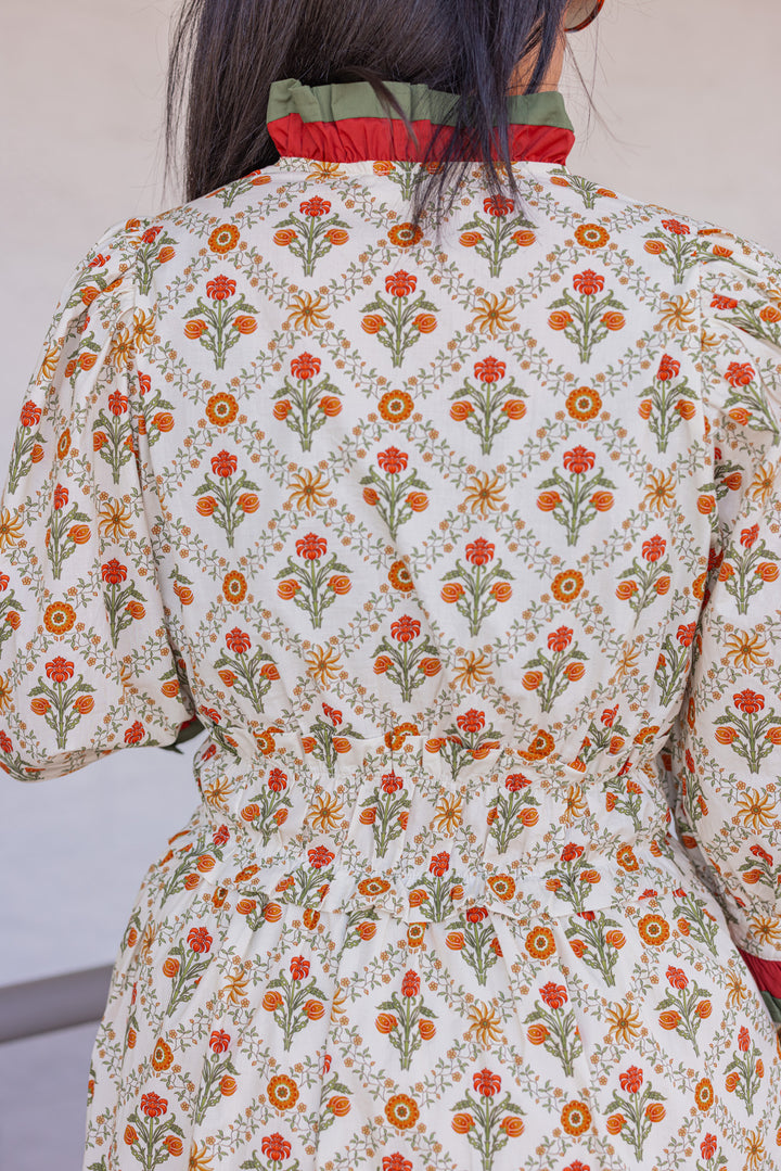 Women's ecru midi dress with orange and green floral print and ruffle trim by Entro showing up close back view