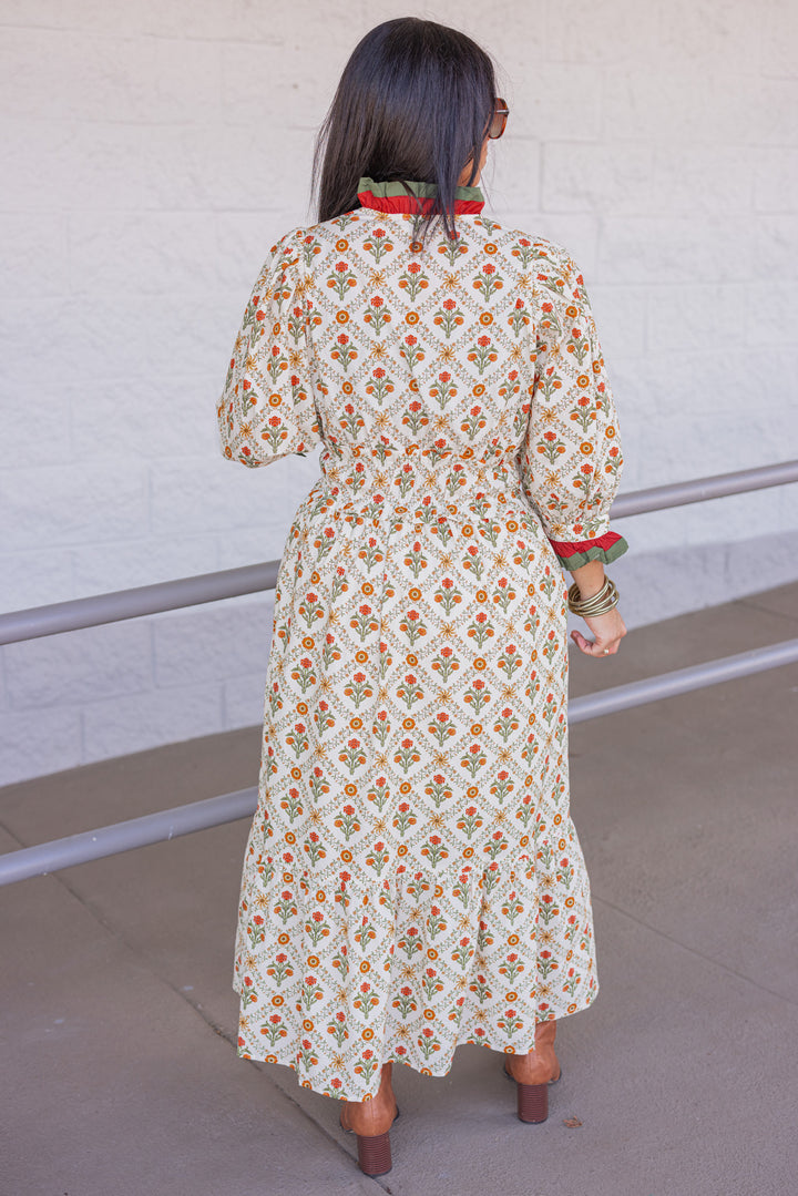 Women's ecru midi dress with orange and green floral print and ruffle trim by Entro showing full back view