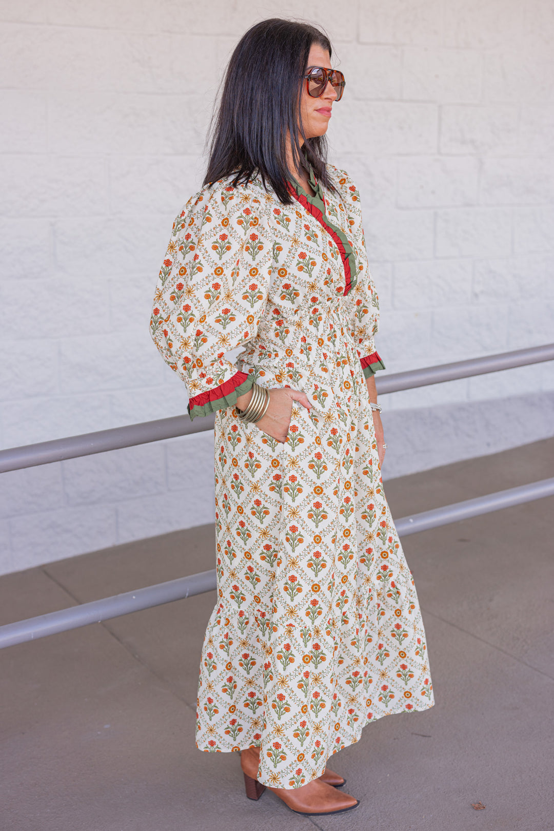 Women's ecru midi dress with orange and green floral print and ruffle trim by Entro showing full side view