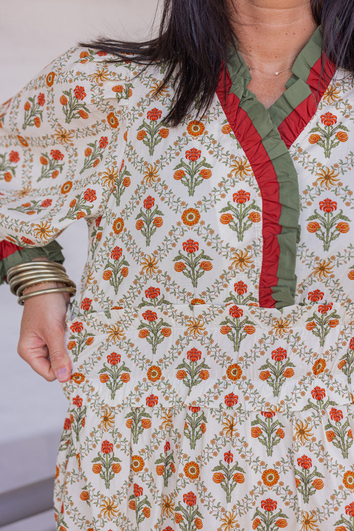 Women's ecru midi dress with orange and green floral print and ruffle trim by Entro showing close look at floral pattern