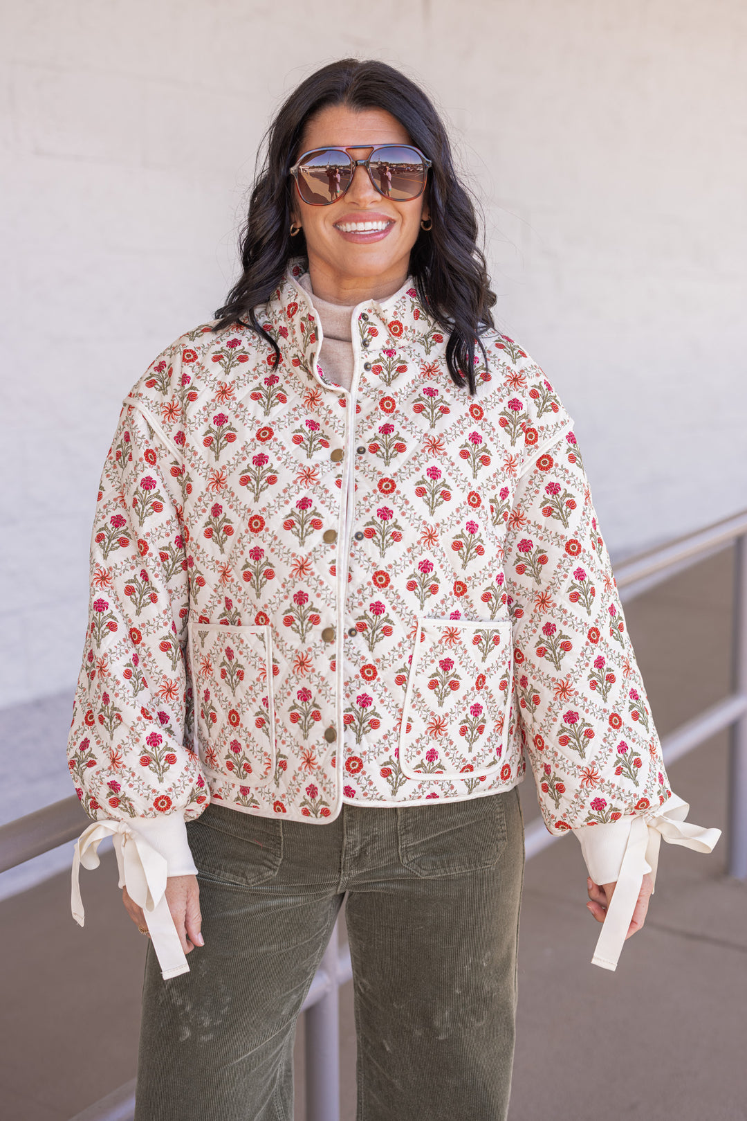 Women's ivory, red and olive floral quilted puffer jacket with bow tie detail sleeves by &merci showing front view