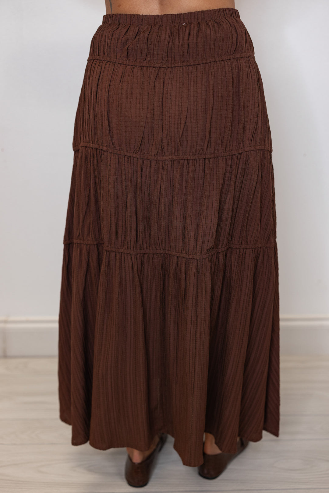 Women's pleated chocolate brown tiered midi skirt with bow ties down one side by In February showing up close back view