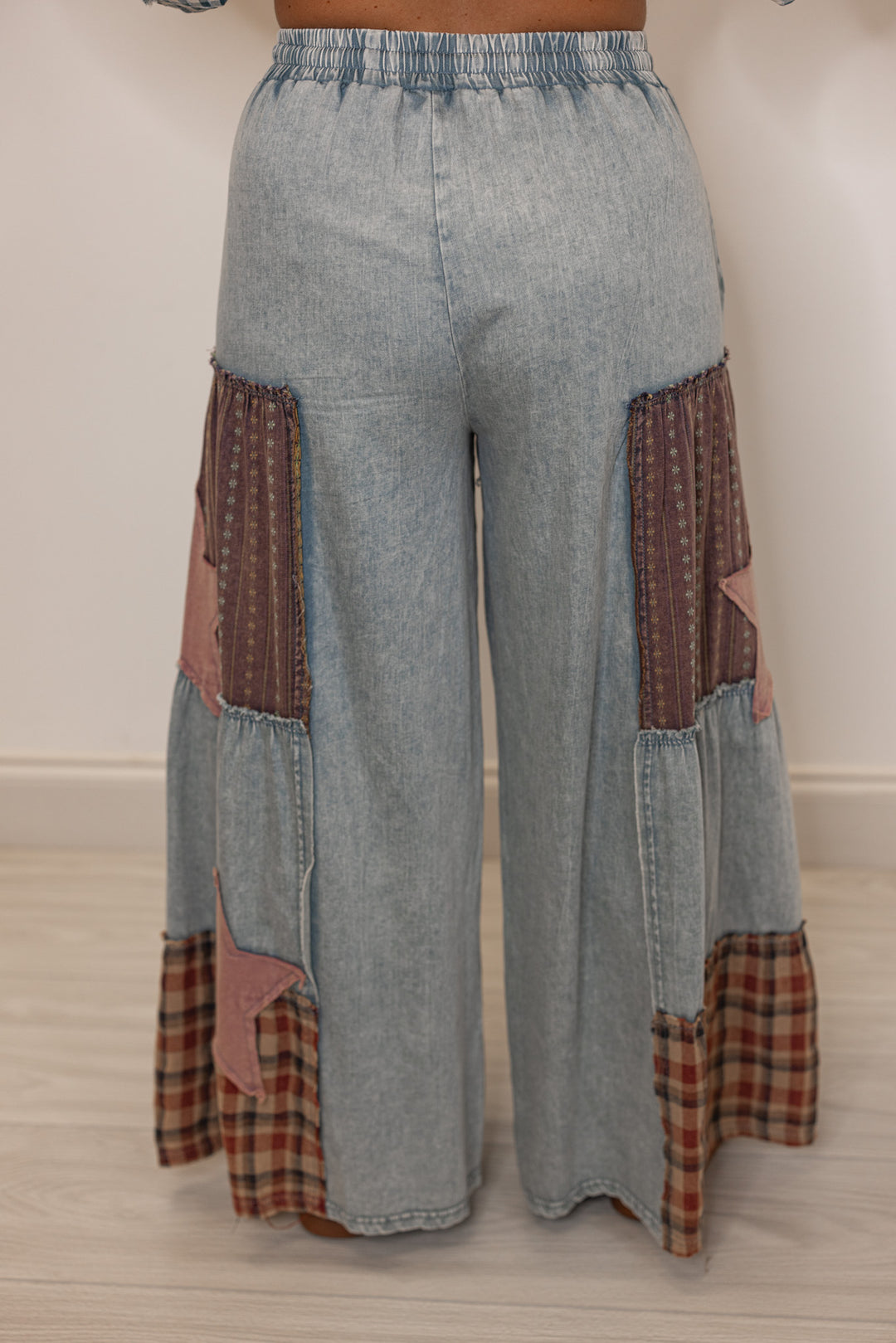 Back view of women's patchwork light weight denim pants with star and plaid  patterns