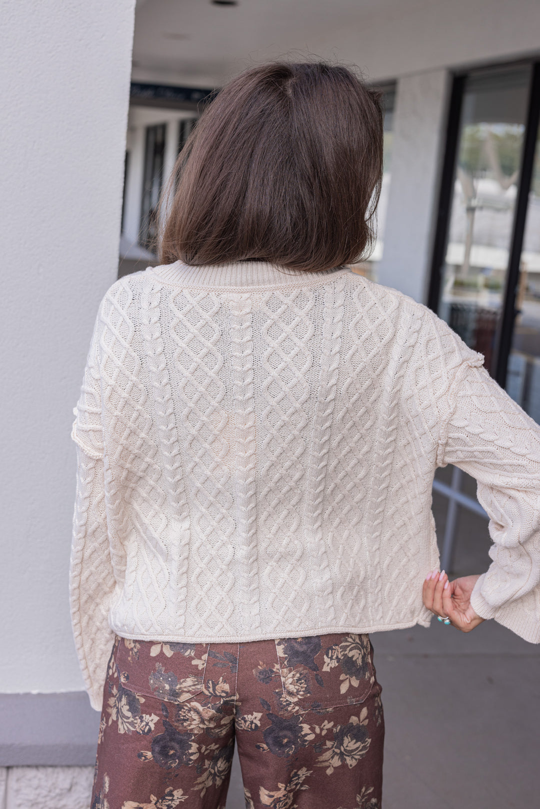 Women's cable knit button front sweater cardigan in ecru with ribbed trim by Entro showing up close back view