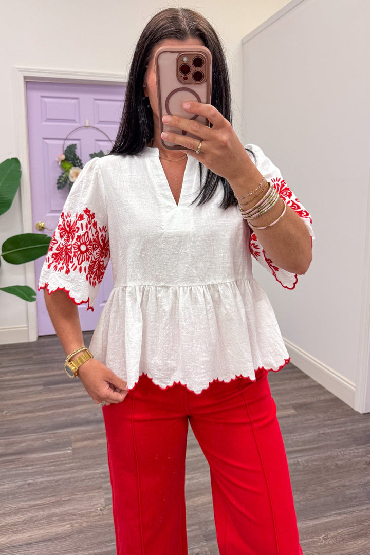 ivory scallop trim peplum top with red embroidered flower details