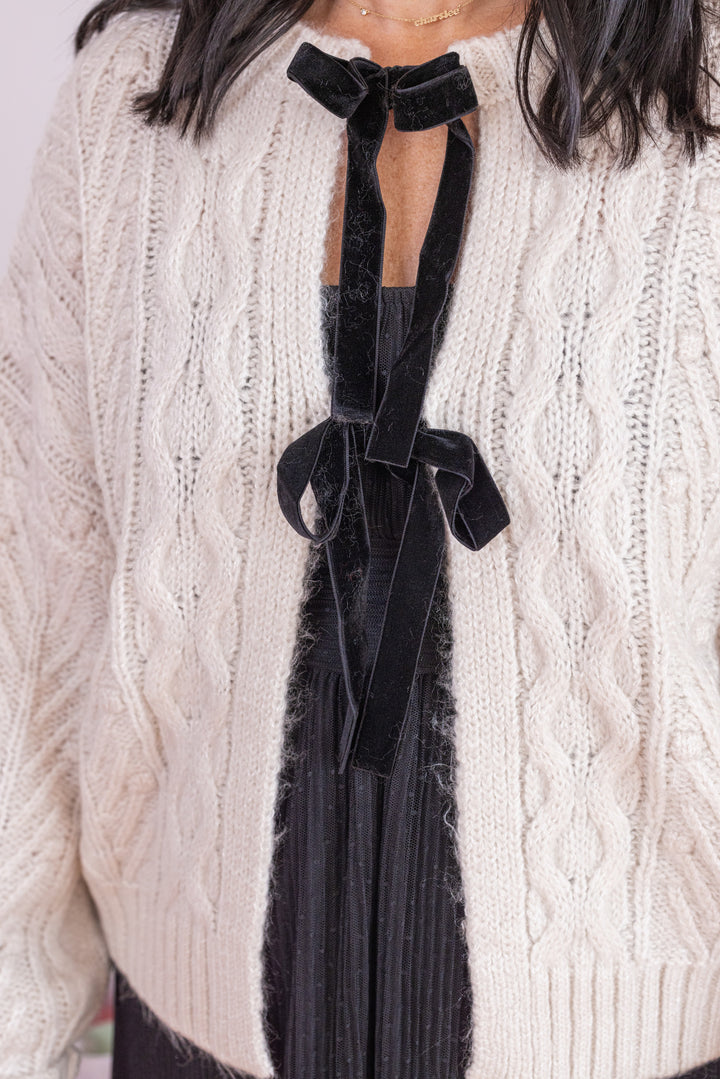 Women's oatmeal cable knit sweater cardigan by Blu Pepper showing black bow tie closures