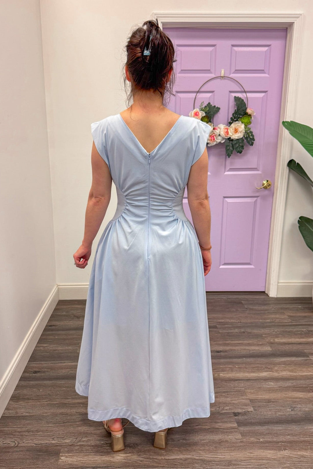 Back view of Women's light blue cinched panel waist midi dress