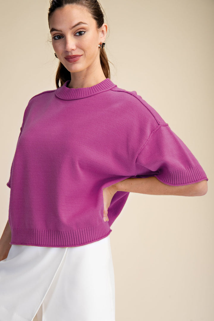 Magenta pink knit top with 1/2 length sleeves and crew neckline