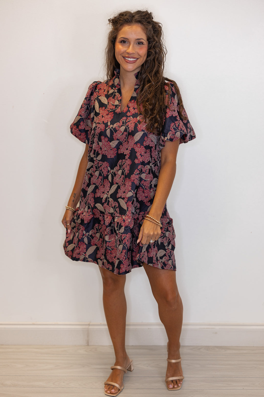 Woman's burgundy and black floral printed dress with strapy gold heels