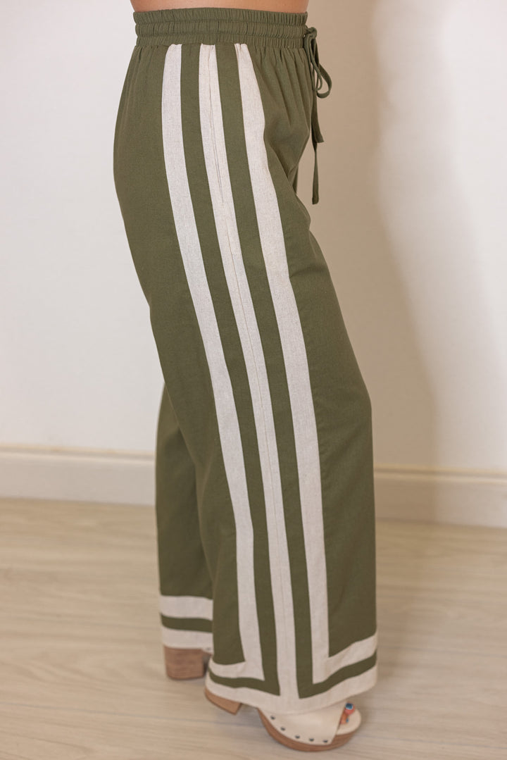 Women's olive green elastic waist linen pants with oatmeal trim throughout by Entro showing side view