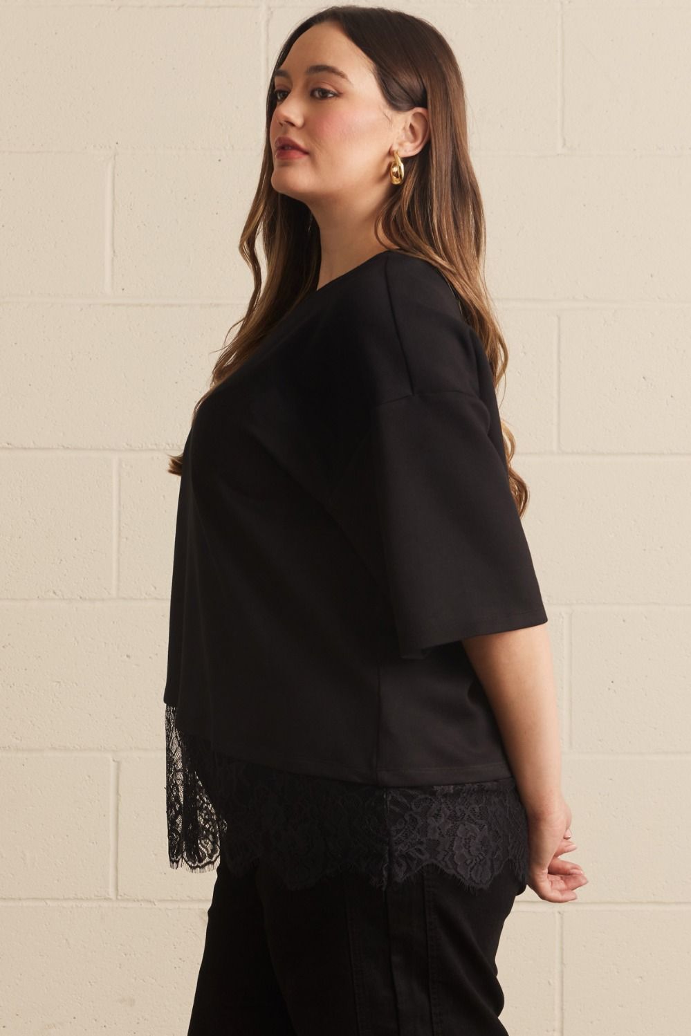 Entro plus size black top with drop shoulder short sleeves and a tiered lace detail at the hem