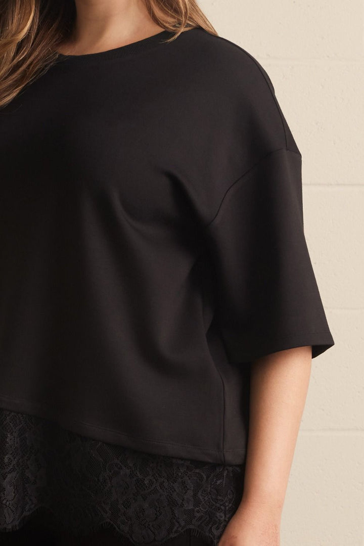 Entro plus size black top with asymmetrical tiered lace detail at the hem and comfortable short sleeves