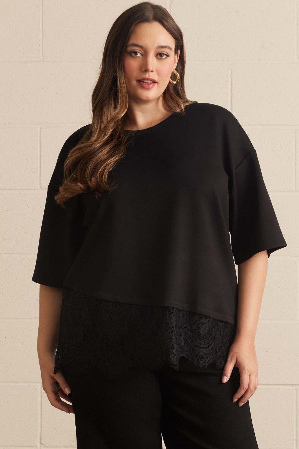 Entro plus size black top with asymmetrical tiered lace detail at the hem
