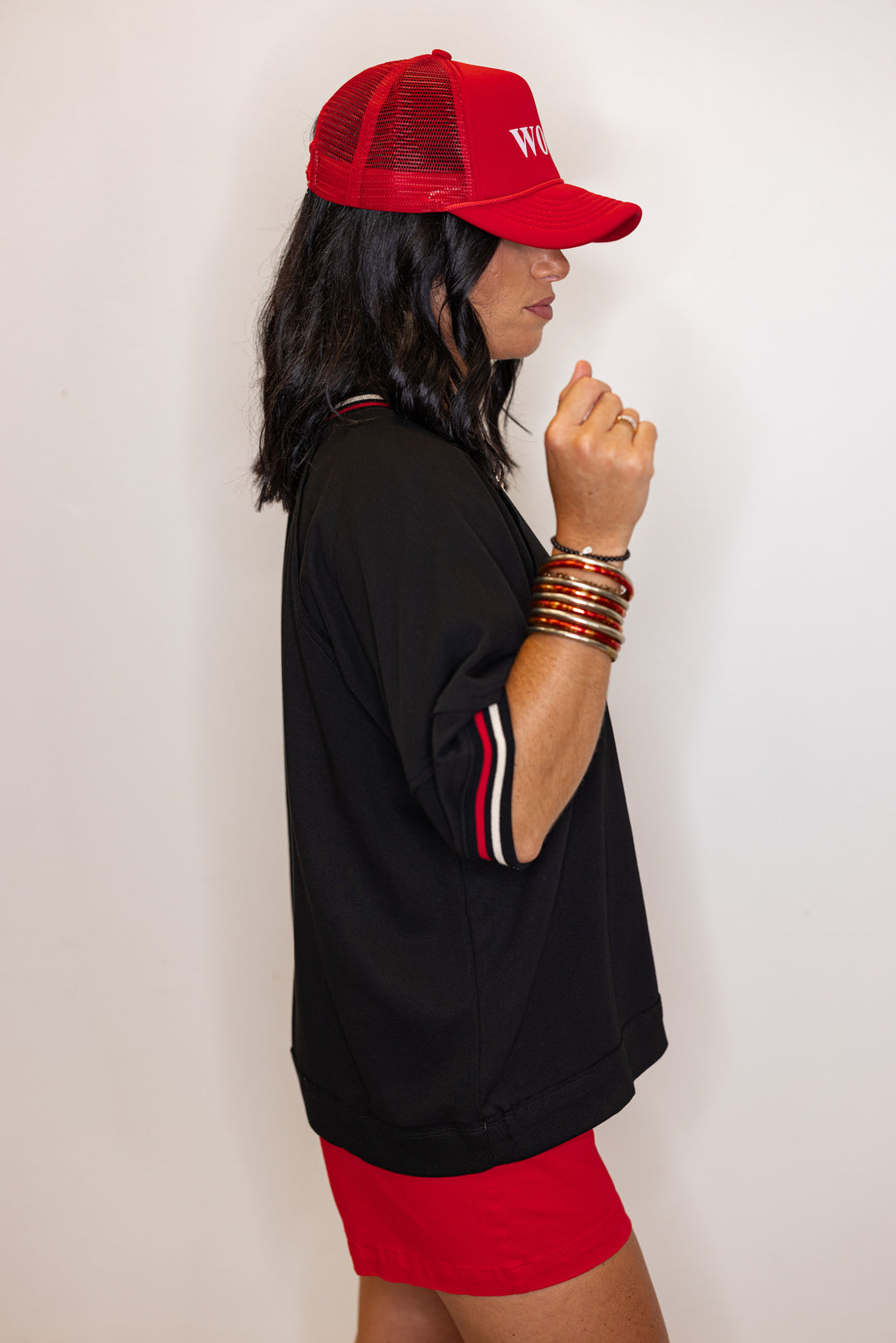 Women's black french terry knit top with cream and red striped trim by Entro showing up close side view