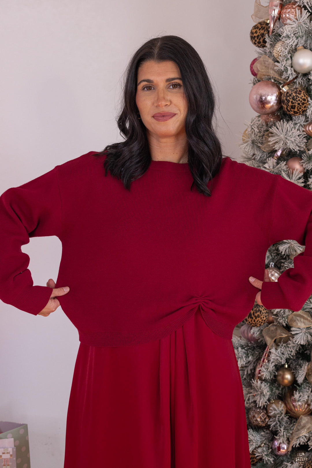 Women's burgundy knit cropped sweater top with knotted detail at the hem by Jodifl showing true to size fit