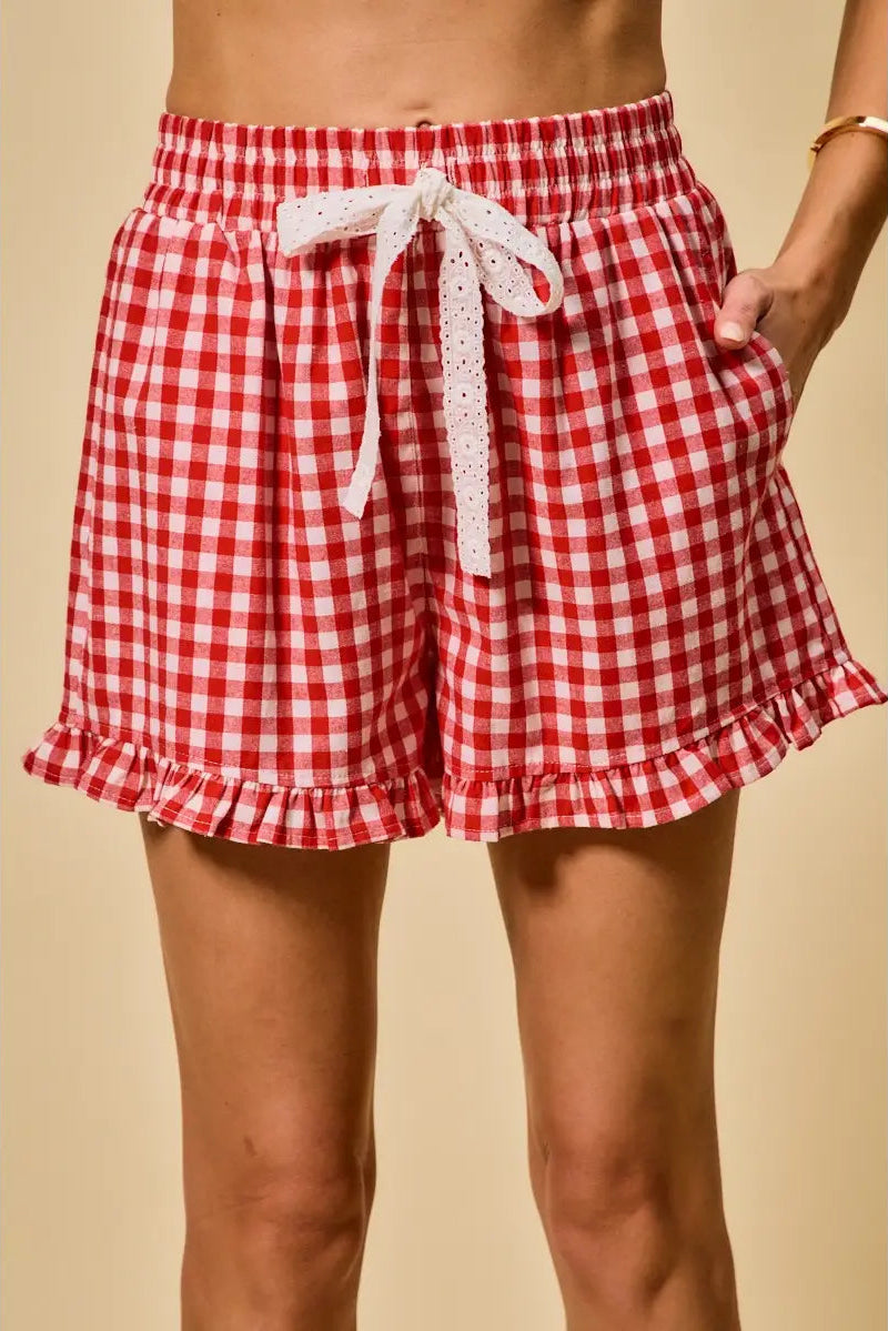 Red and white checkered shorts with lace trim on a beige background