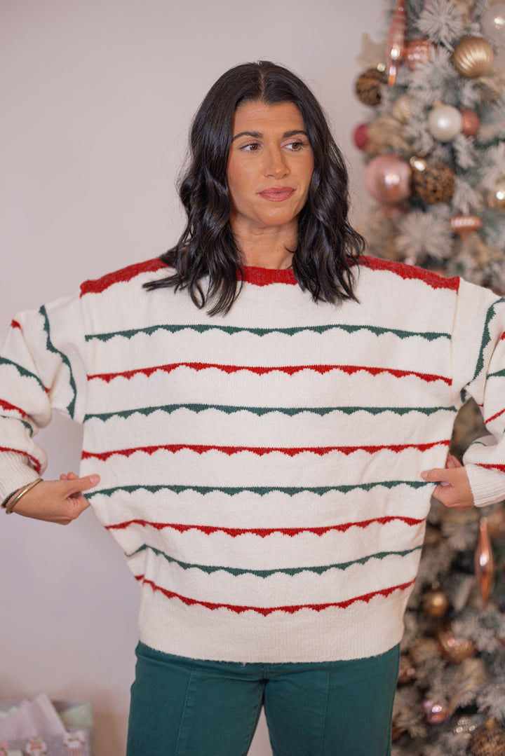 Women's ivory sweater with green and red scalloped stripes by Peach Love California showing true to size fit