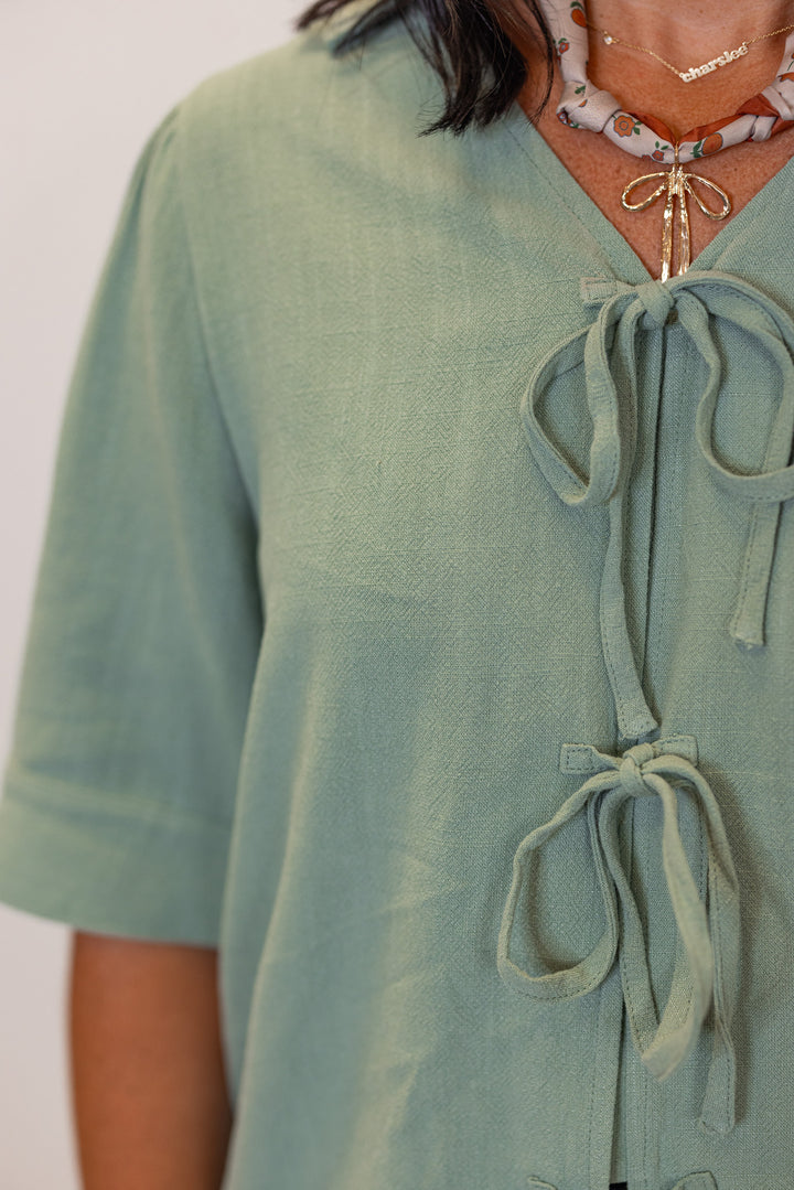 Women's sage green linen bow tie top and elastic waist wide leg pants set by Jodifl showing bow tie front closure