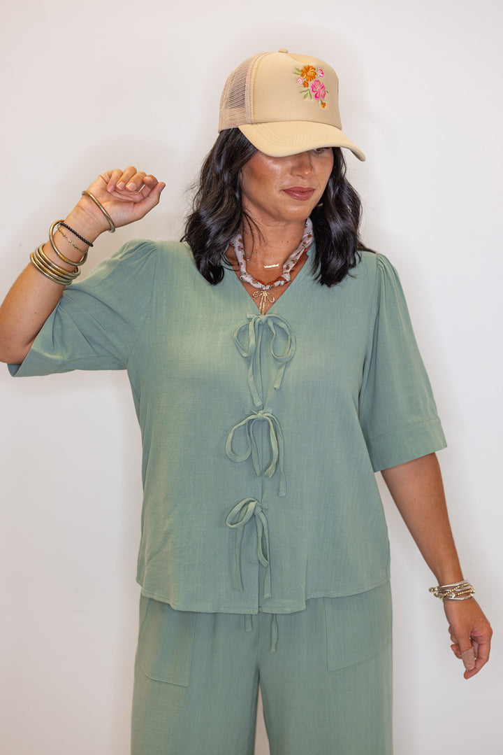 Women's sage green linen bow tie top and elastic waist wide leg pants set by Jodifl showing relaxed silouhette