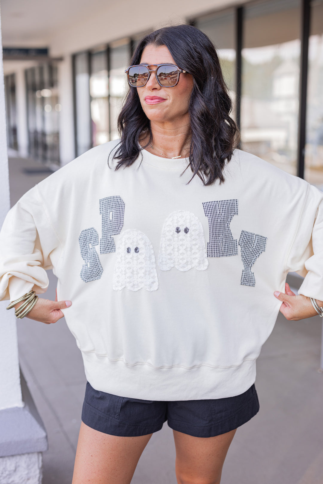 Women's cream sweatshirt with "Spooky" in lace ghosts and black checkered print by Peach Love California showing relaxed fit