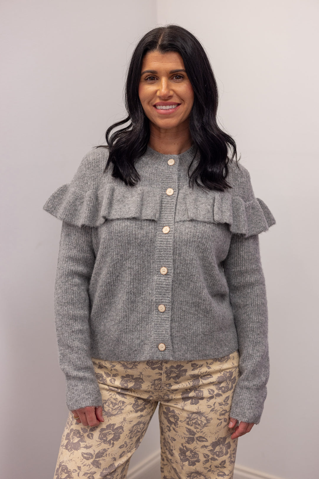 Women's grey knit sweater with a ruffle across the front chest and back shoulders by Wishlist