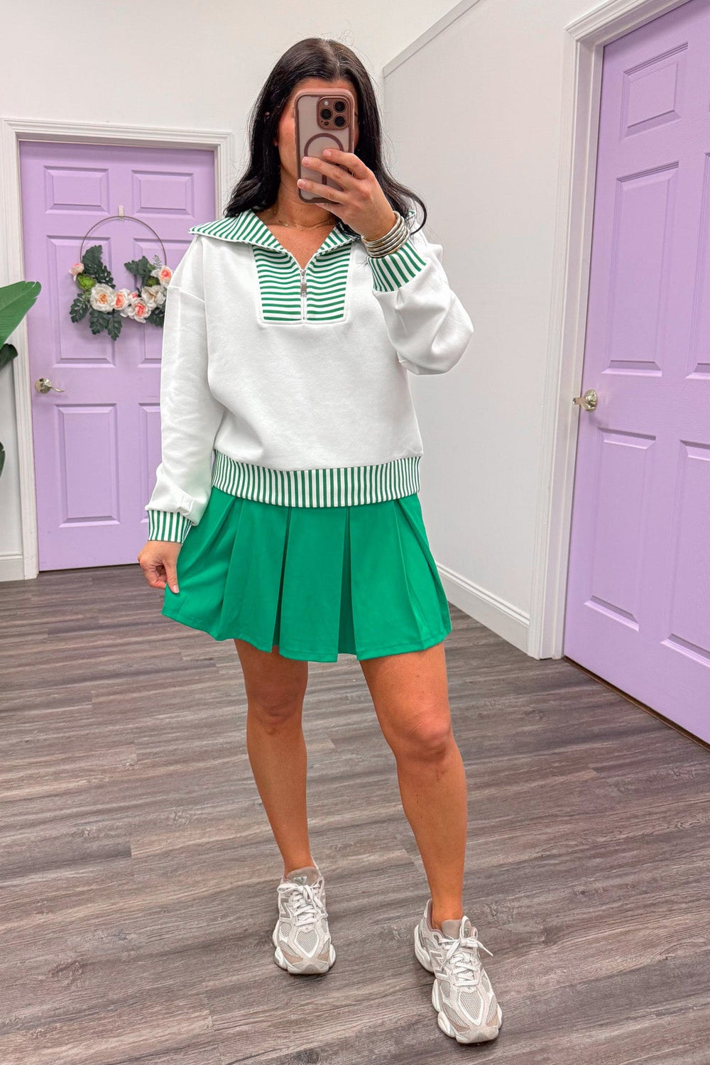 Women's white and green pullover paired with green skort