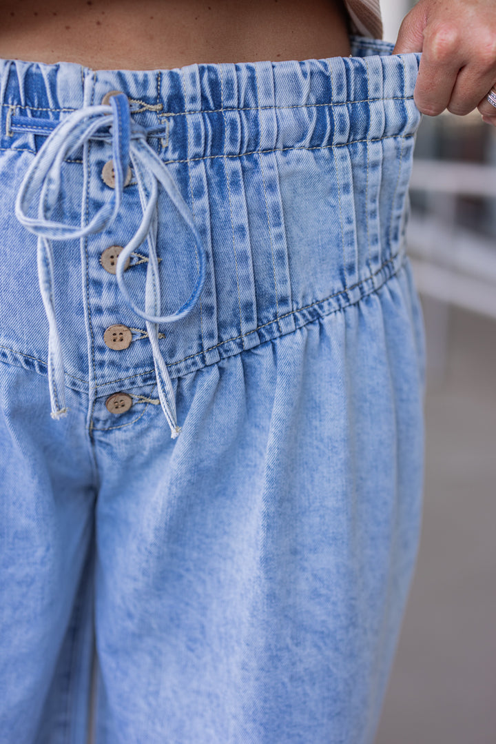 Palazzo style wide leg light blue washed denim pants with button fly by ee:some showing elastic waistband