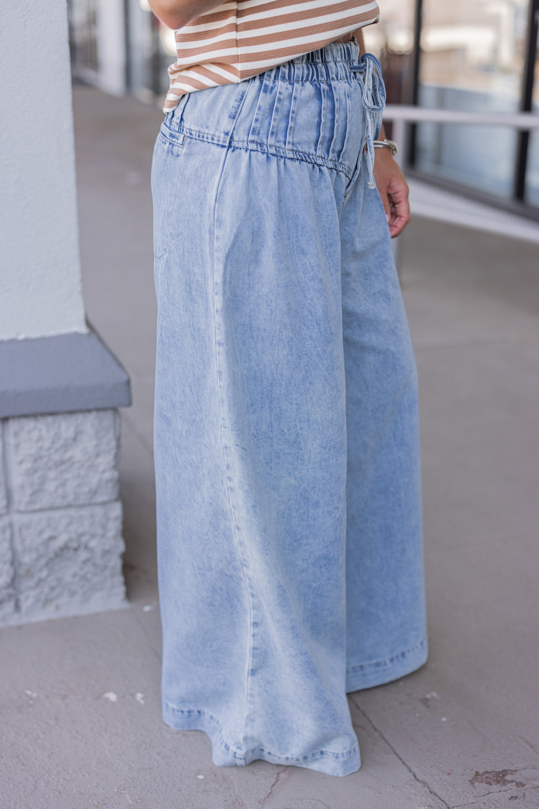 Palazzo style wide leg light blue washed denim pants with button fly by ee:some showing up close side view