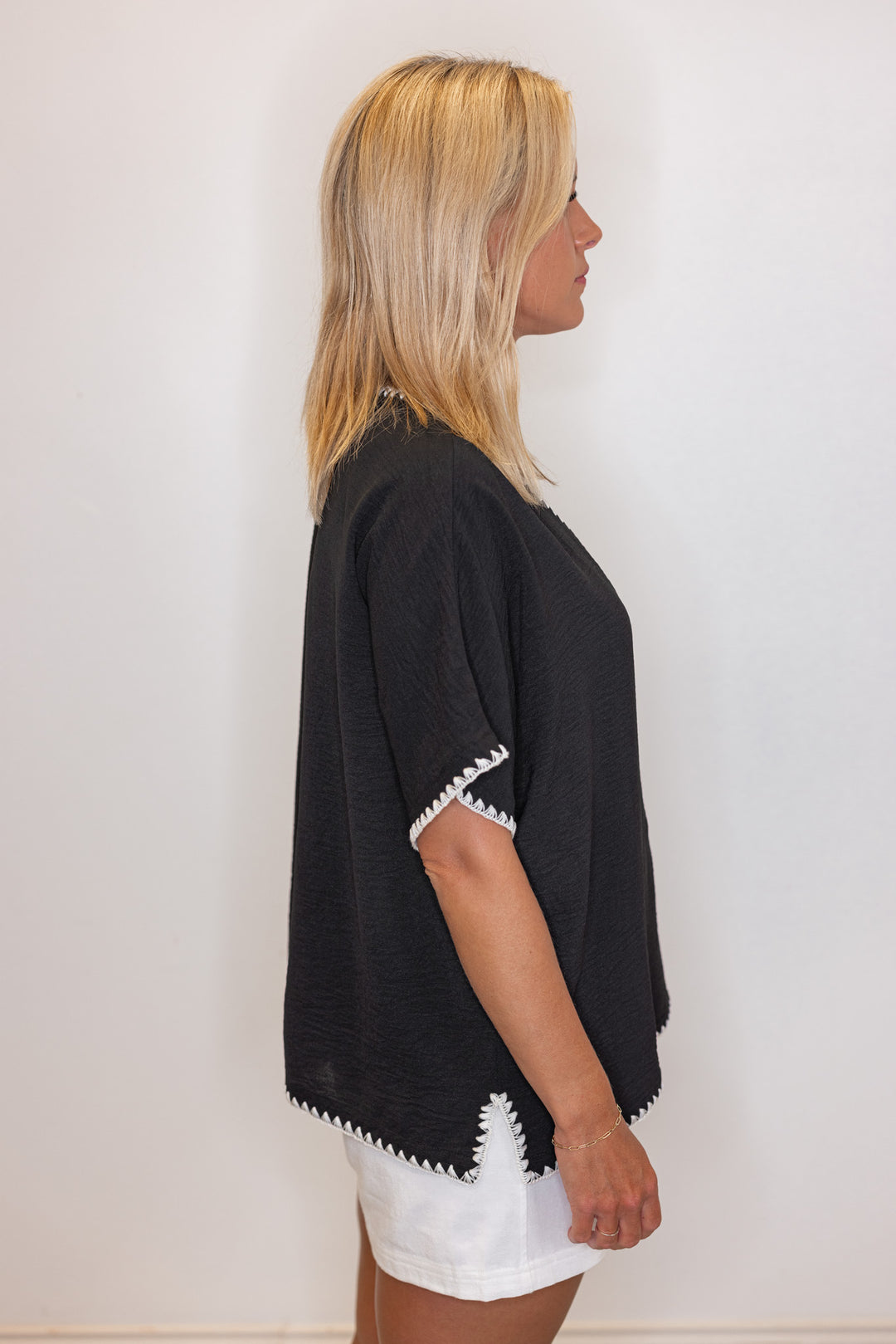 Black lightweight crinkle top with embroidery stitching trim by Jodifl showing side view