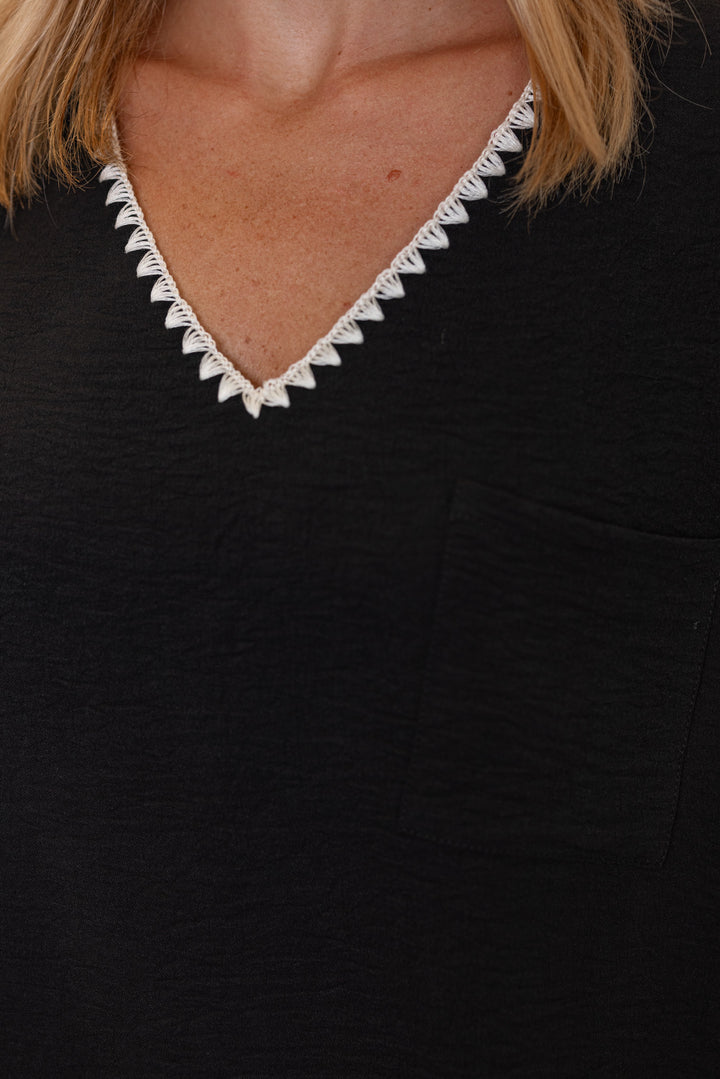 Black lightweight crinkle top by Jodifl showing up close front view of embroidery stitched trim detail