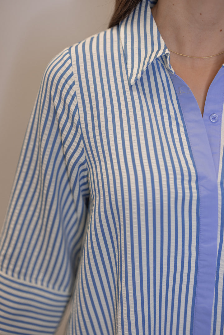 Women's striped blue maxi dress by Entro showing collared neckline and hidden button details