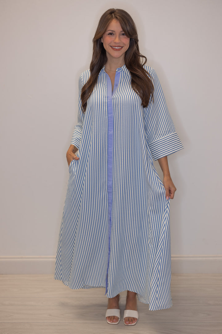 Women's striped blue maxi dress by Entro showing side pockets and flowy skirt