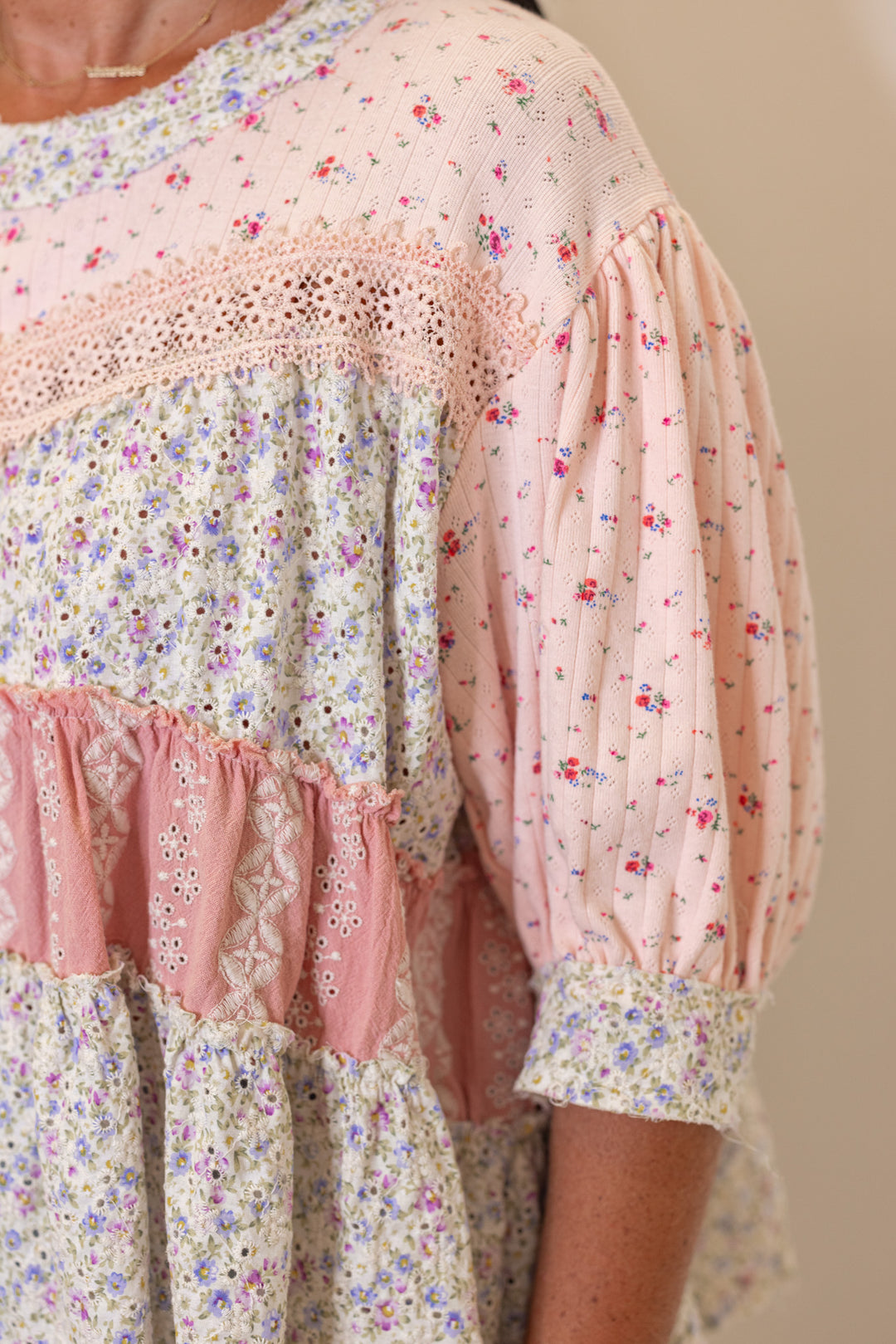Women's pink and ivory floral patchwork top with embroidery and eyelet details by POL showing puff sleeve detail