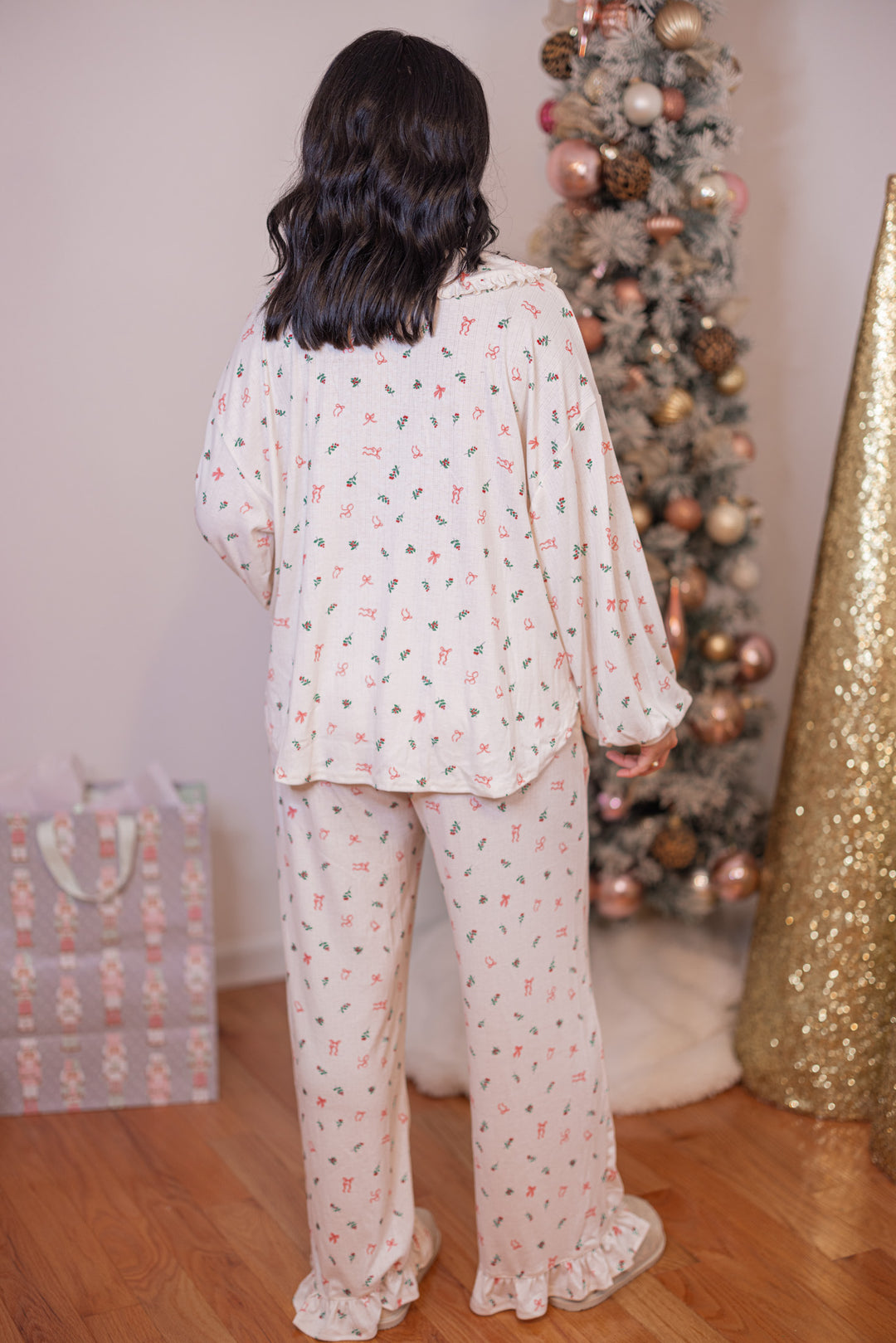 Women's cream pointelle knit pajamas with red, pink and green holly and bow tie print by Peach Love California showing full back view