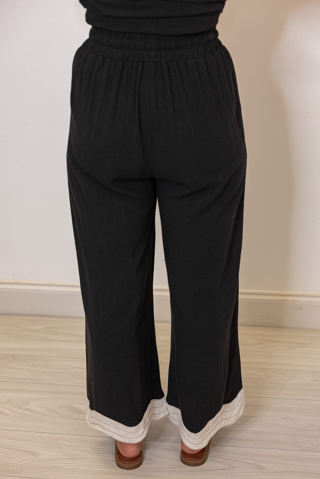 Umgee linen wide leg pants in black with oatmeal scalloped hem by Umgee showing back view
